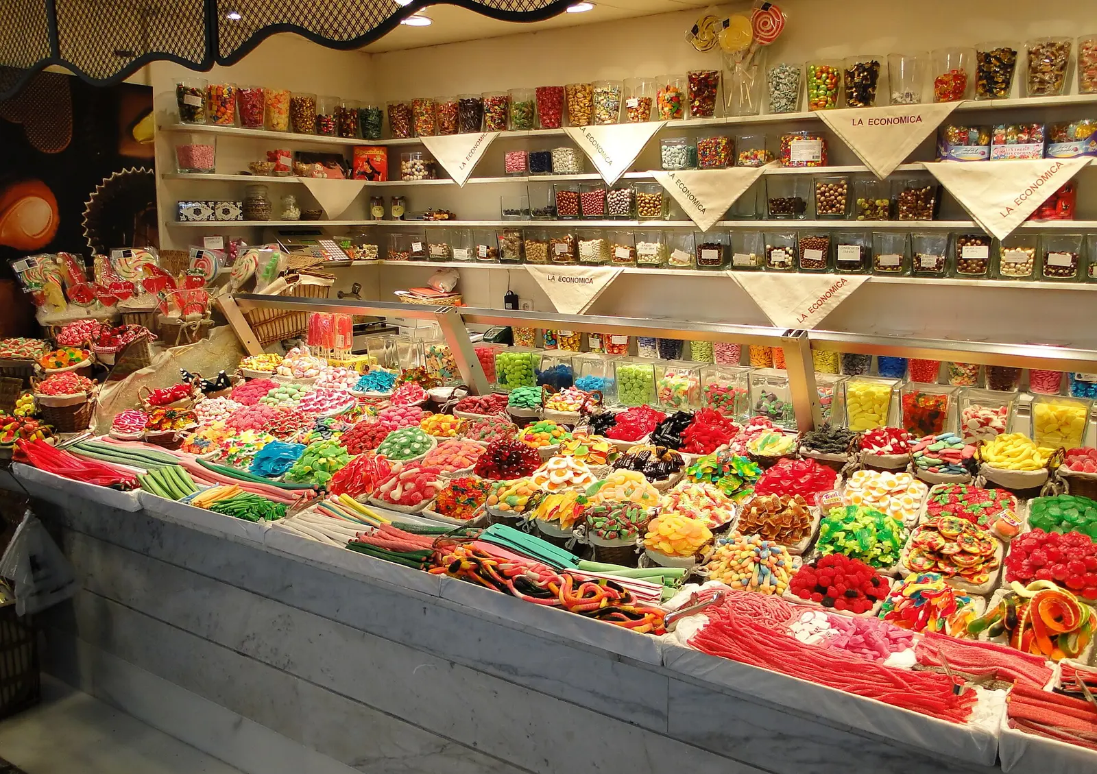 Stalls piled with sweets and fruit inside La Boqueria