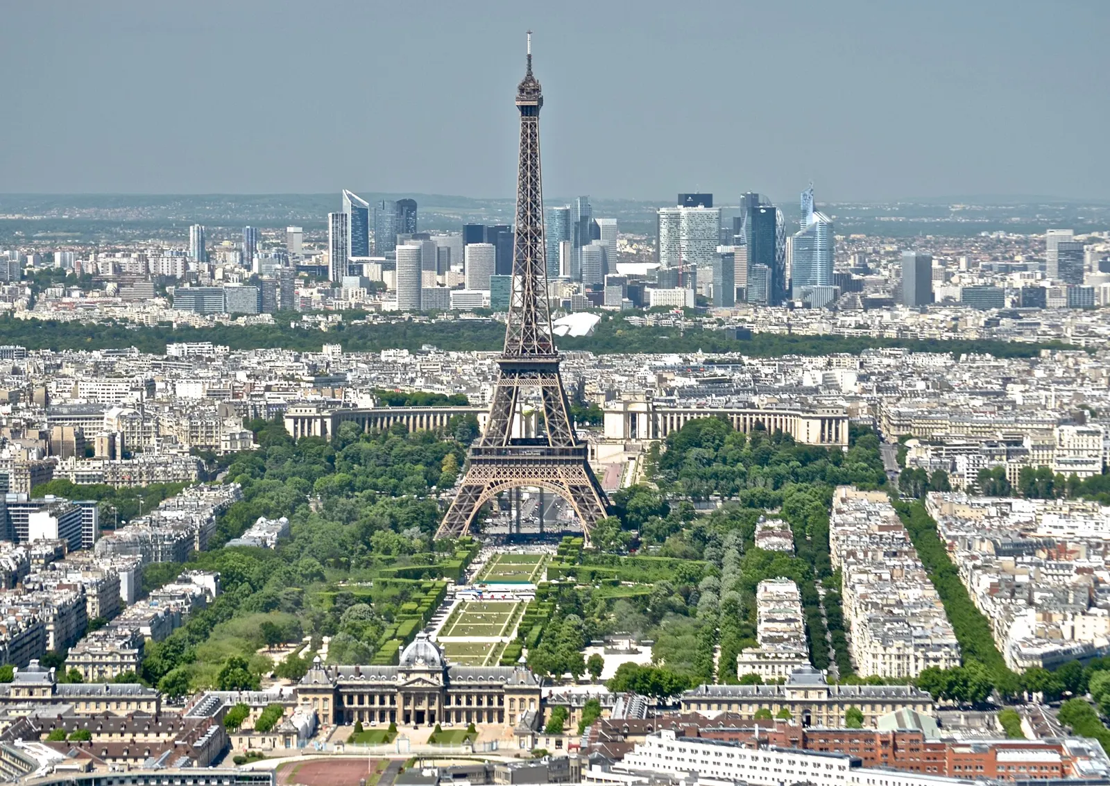 The Eiffel Tower and the Champ de Mars seen from above, with La Defense skyscrapers in the distance