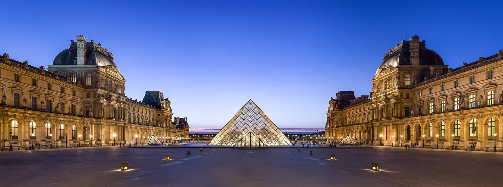 The Louvre pyramid and courtyard at dusk